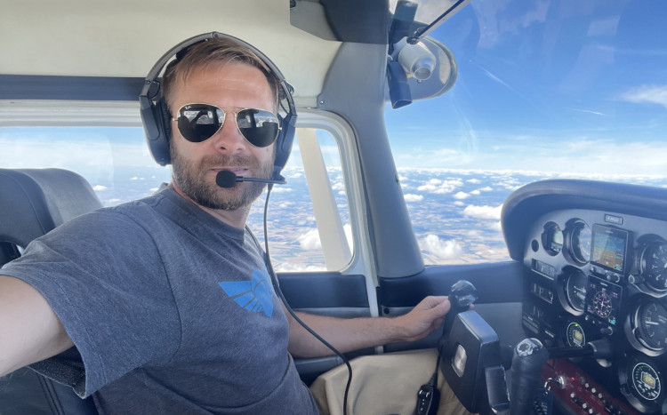 Pilot awionetki w przeciwsłonecznych okularach i założonej słuchawce do rozmów
