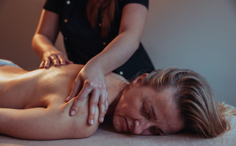 Kobieta podczas masażu pleców, który polega na uciskaniu i ugniataniu skóry