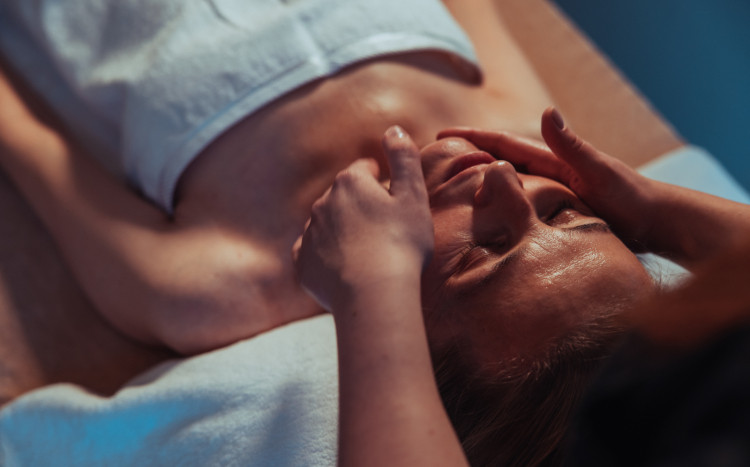 Zrelaksowana kobieta podczas masażu twarzy