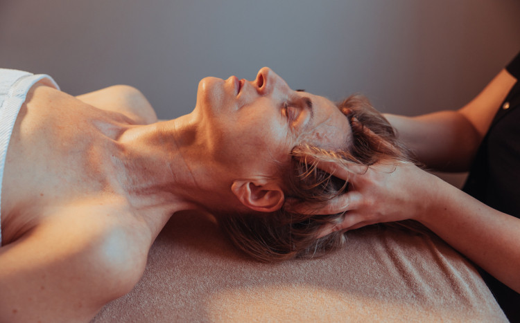 Kobieta podczas masażu głowy, który polega na rozluźnieniu skóry
