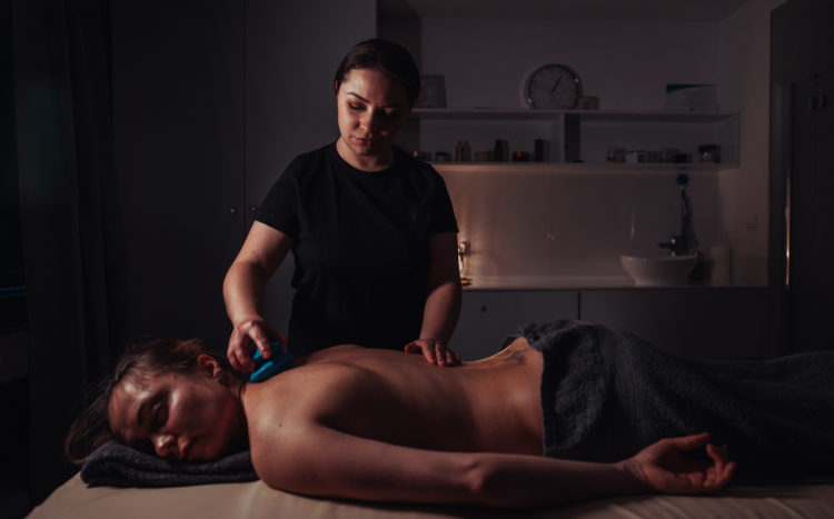 Masażystka wykonująca masaż ujędrniający za pomocą chińskiej bański