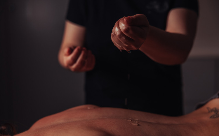 Olejek do masażu wylatujący z dłoni masażystki