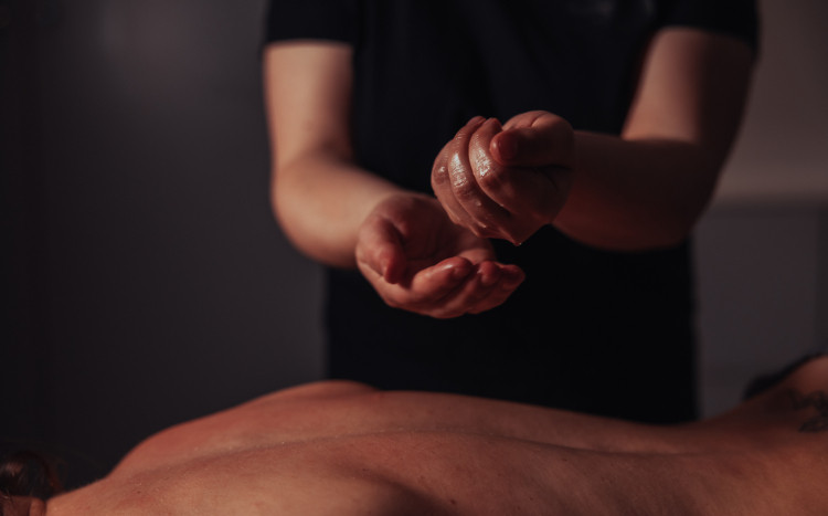 Olejek do masażu wylatujący z dłoni masażystki