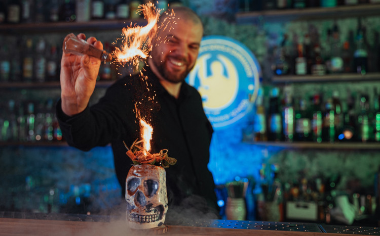 Barman dodający do drinka składnik, który stwarza ogień