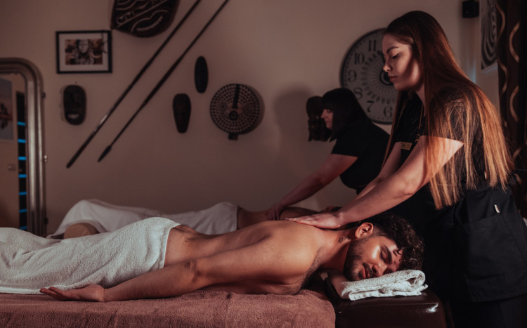 masażystka masująca mężczyznę leżącego na brzuchu