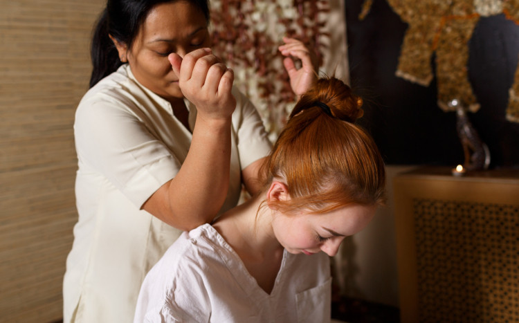 masażystka używa łokci do masowania karku kobiety