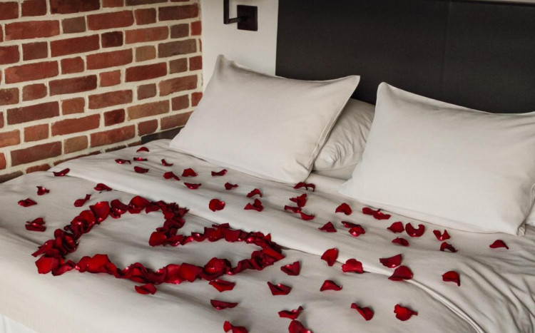 Łóżko pokryte płatkami róż
