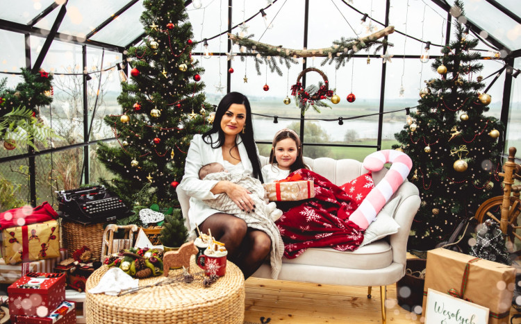 Mama i dwójka dzieci pozujący do zdjęcia w Szklarni na Skarpie urządzonej w świątecznym stylu