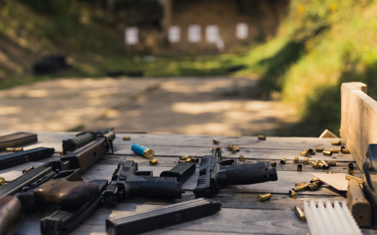 Broń i amunicja leżące na drewnianym stole