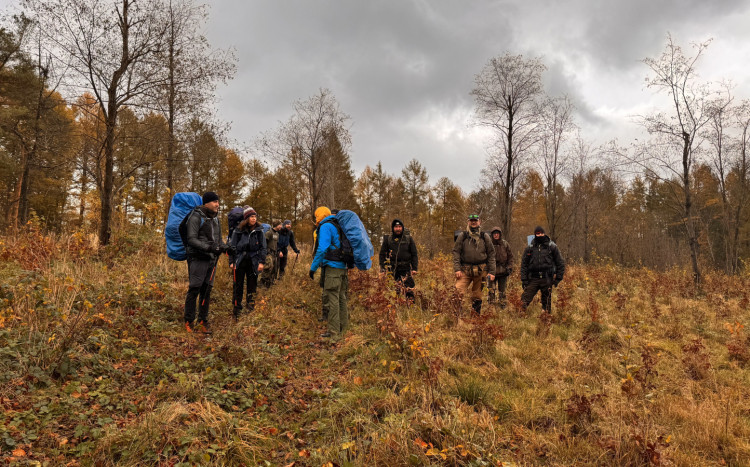 Grupa osób podczas szkolenia w jesiennym lesie