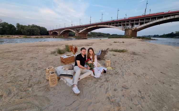 Para zakochanych pozująca do zdjęcia na piasku podczas randki