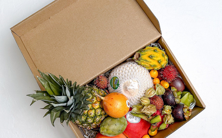 Ananas i kolorowe egzotyczne owoce w kartonowym pudełku