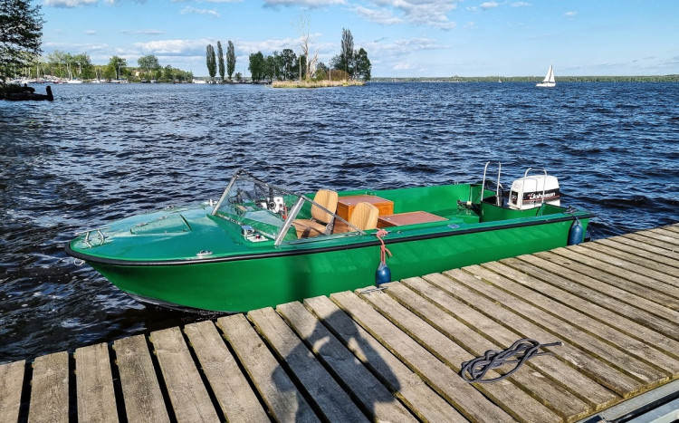 Zielona łódź motorowa przycumowana na Wiśle
