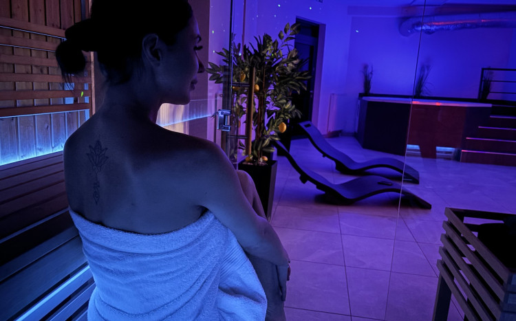 Kobieta w białym ręczniku w klimatycznie oświetlonym SPA