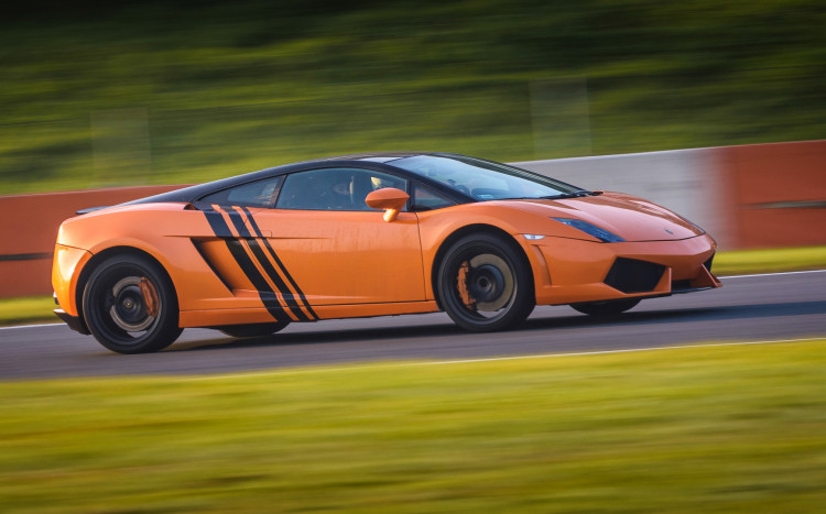 Pomarańczowe Lamborghini Gallardo pędzące po torze