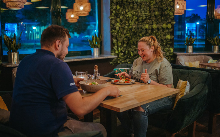 Szczęśliwa kobieta i mężczyzna siedzący przy stoliku w restauracji