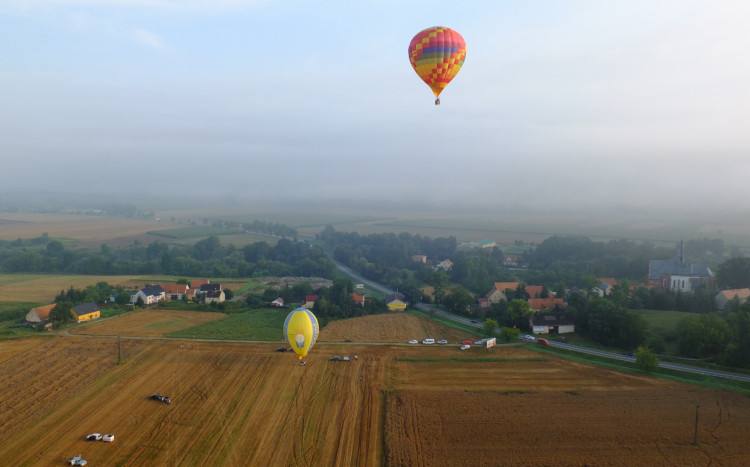 dwa balony unoszące się nad polami