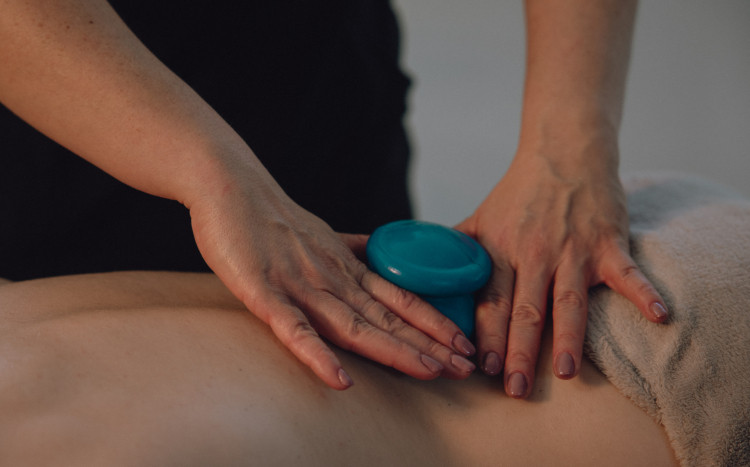 Kobiece dłonie trzymające niebieską bańkę chińską podczas masażu
