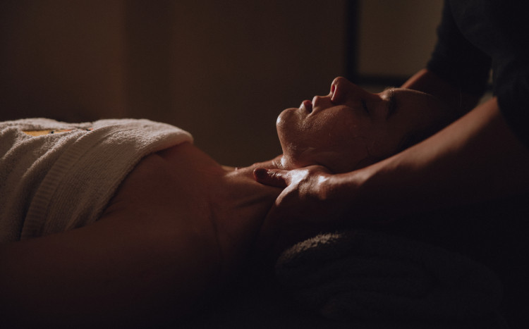 Kobieta leżąca na plecach podczas masażu karku