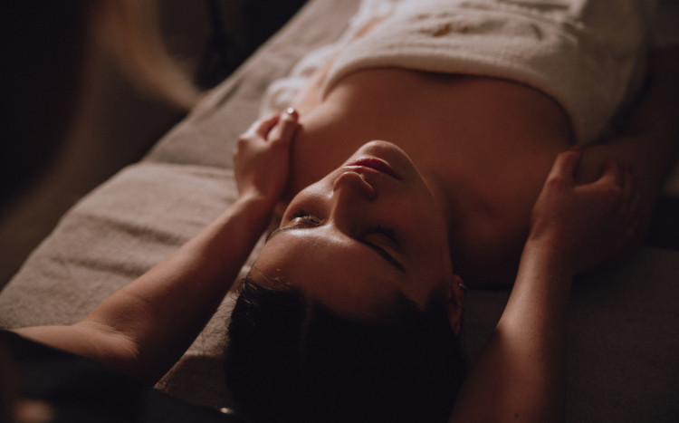 Kobieta leżąca na plecach podczas masażu ramion