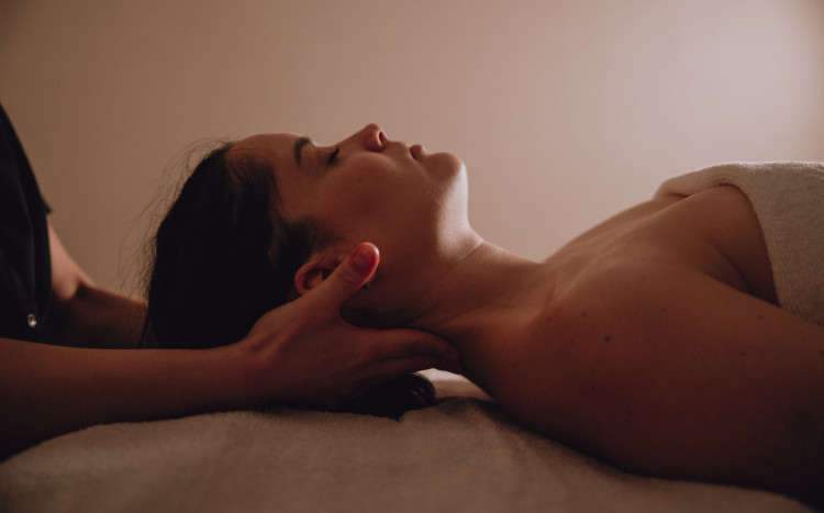 Masażystka wykonująca odprężający masaż szyi u kobiety