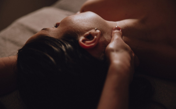 Kobieta leżąca na plecach podczas odprężającego masażu ciała