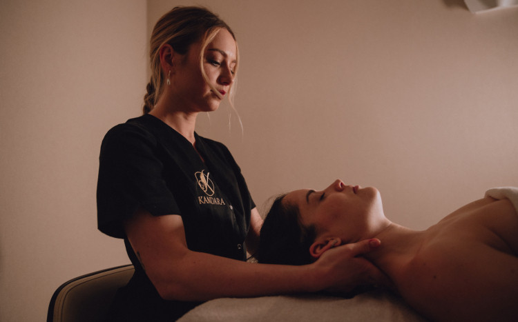 Masażystka wykonująca odprężający masaż karku u kobiety