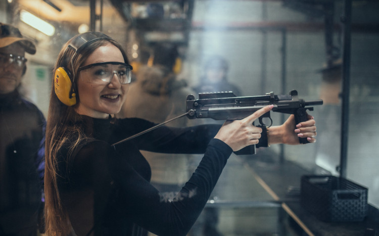kobieta na strzelnicy pozuje trzymając broń