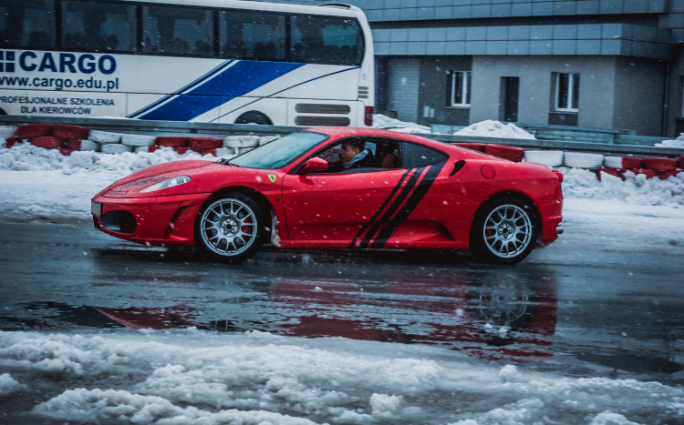 Czerwone Ferrari jadące po ośnieżonym torze