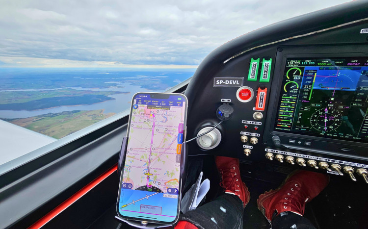 zbliżenie na aplikację w telefonie przeznaczoną dla samolotów, w oddali widoki z lotu ptaka