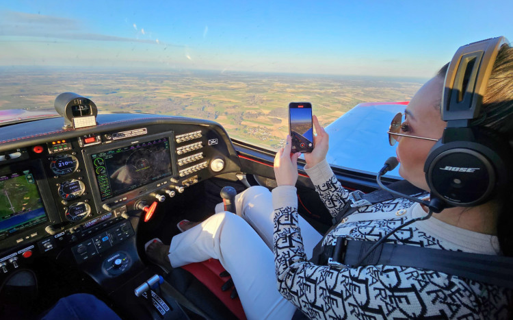 pasażerka siedząca w samolocie podczas lotu nagrywająca piękne widoki z lotu ptaka