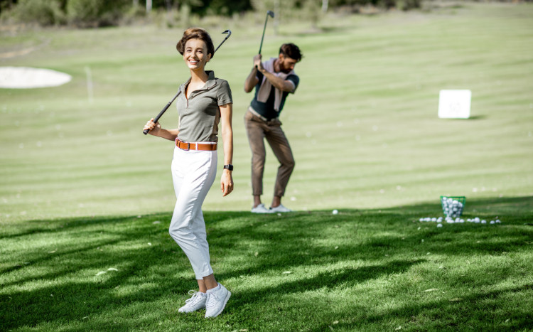 kobieta pozuje z kijem do golfa