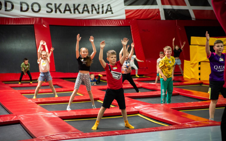 Dzieci na trampolinach wykonujące to samo ćwiczenie