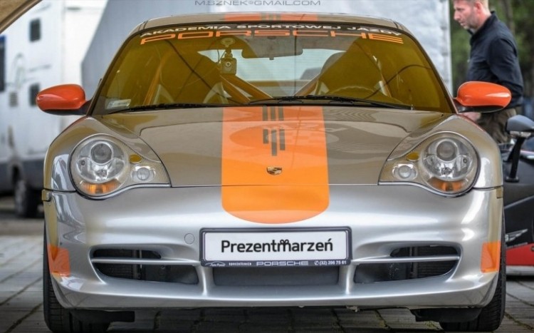 Srebrne Porsche, pomarańczowe lusterka, napisy na szybie