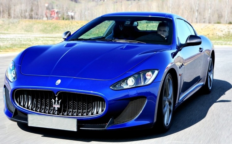 Niebieskie maserati granturismo pędzące po torze wyścigowym