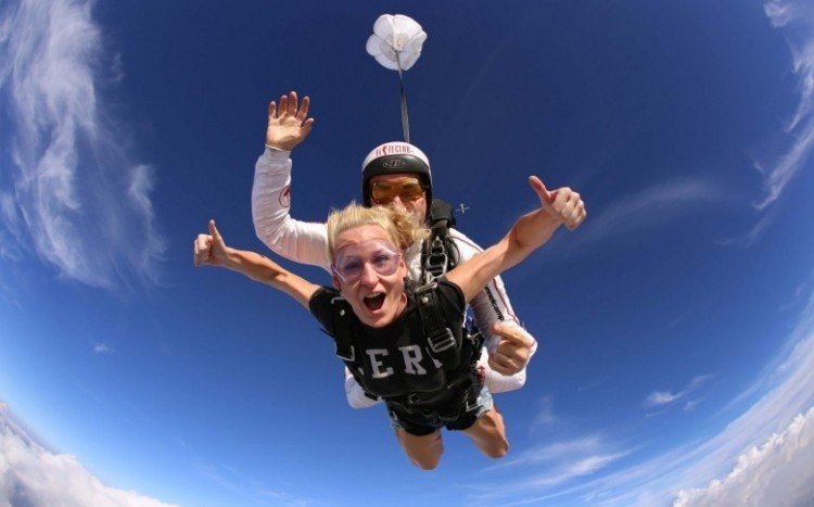młoda dziewczyna skacze ze spadochronem w tandemie z instruktorem