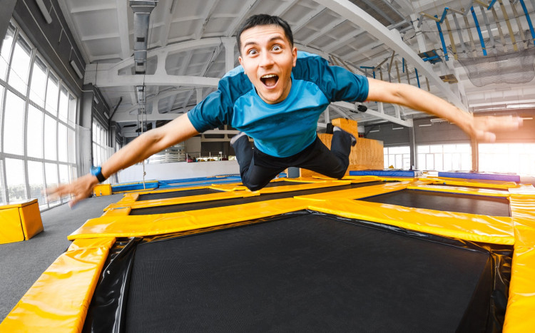 mężczyzna wysoki unosi się na trampolinie