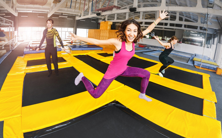 uśmiechnięta kobieta skacze z uniesionymi rękami