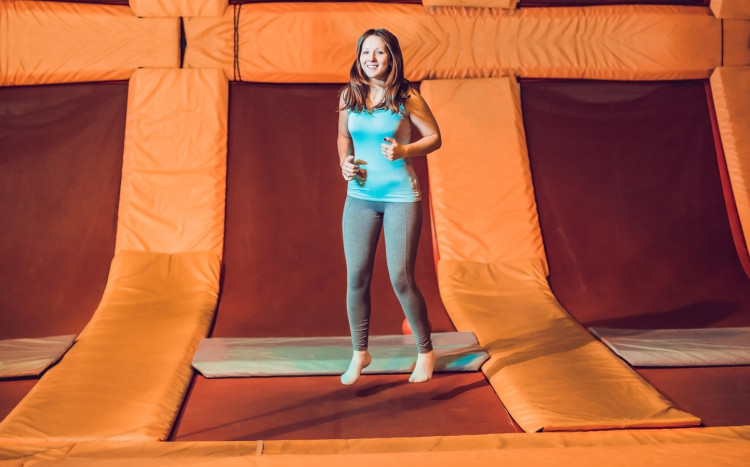 kobieta podskakuje na czerwonej trampolinie