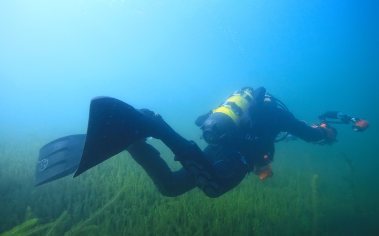 nurek poszukuje przedmiotów pod wodą