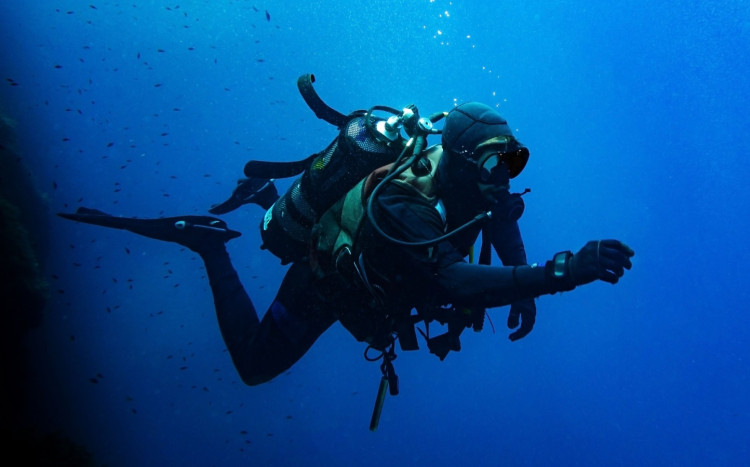 mężczyzna nurkuje w skafandrze z butlą