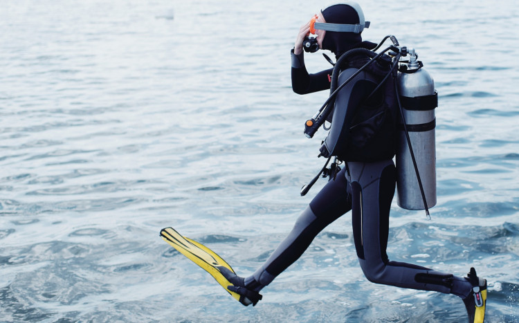 nurek wskakuje do wody z pomostu