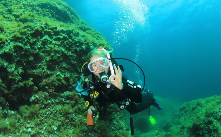 kobieta pokazuje OK w trakcie nurkowania