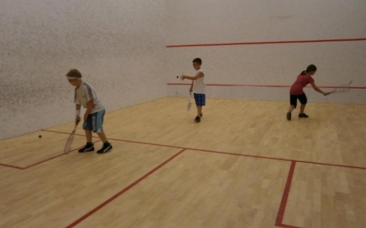 dzieci uczące się grać w squasha