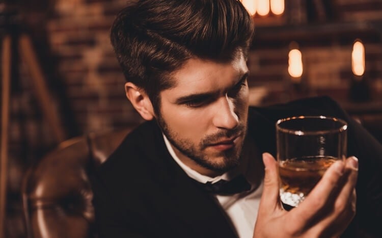 przystojny mężczyzna ze szklanką whisky