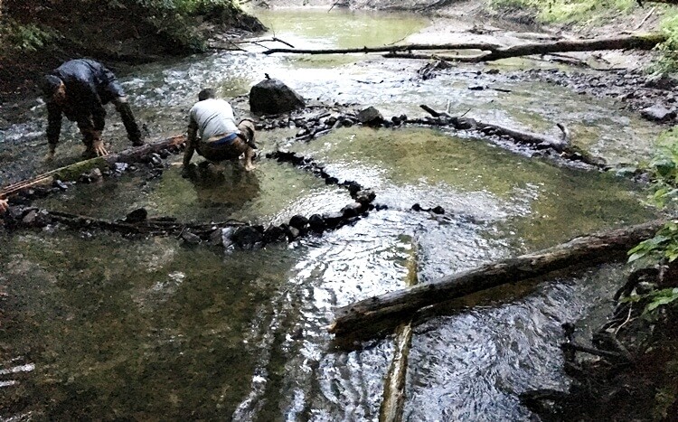 mężczyźni budują pułapkę na ryby