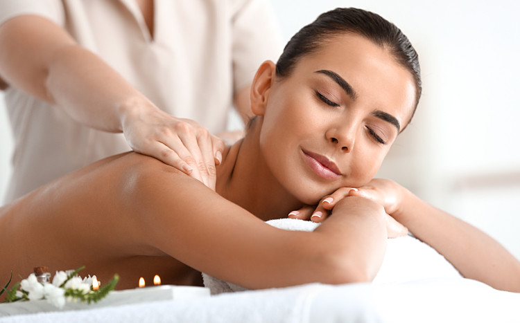 Zrelaksowana kobieta podczas masażu górnej części pleców