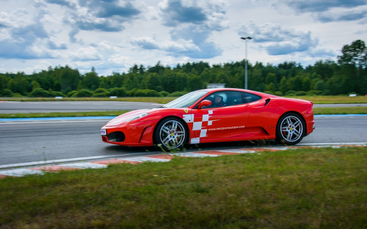 Czerwone Ferrari F430 bokiem na torze