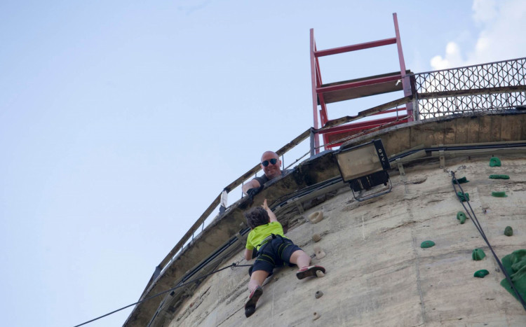 instruktor pomaga chłopcu wspiąć się na szczyt komina