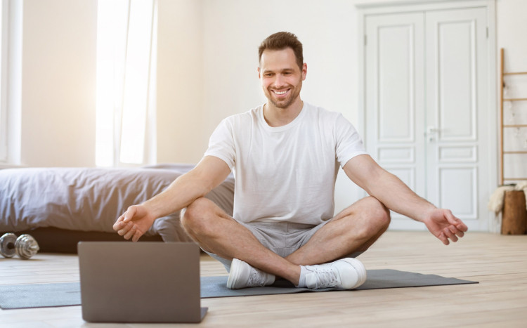 mężczyzna praktykujący medytację online